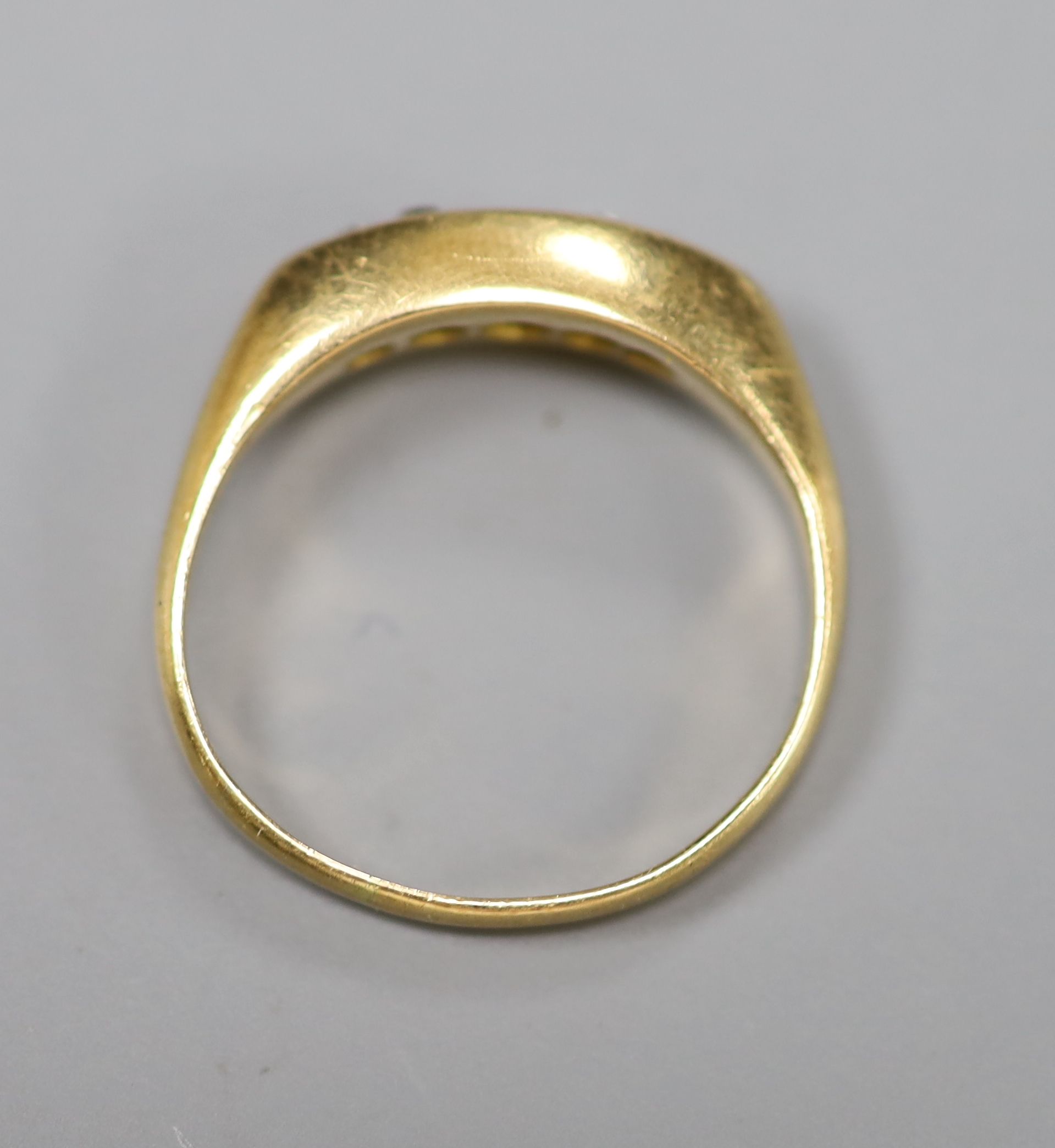 An 18ct gold and five stone diamond set half hoop ring, size J, gross 3 grams.